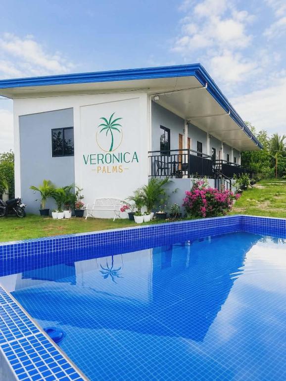 a villa with a swimming pool in front of it at Veronica Palms in Pooc
