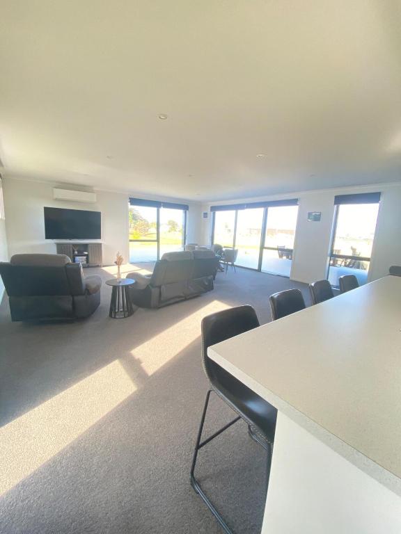 a large living room with a table and chairs at Springhill at The Beach in Karikari Peninsula
