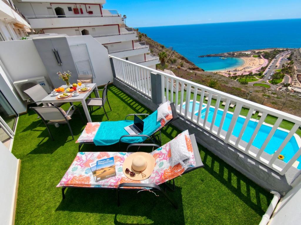 a balcony with a table and chairs and the ocean at Incredible Sunsets in Puerto Rico de Gran Canaria