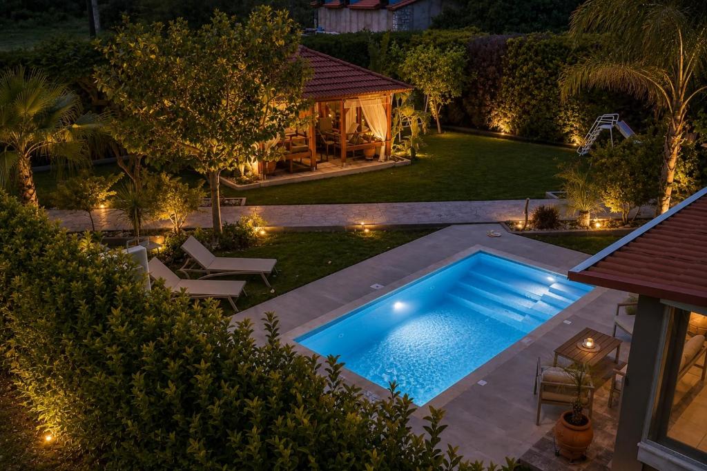 an overhead view of a swimming pool in a backyard at night at Sea Breeze & Nature villa, with heated pool and garden retreat in Kremasti