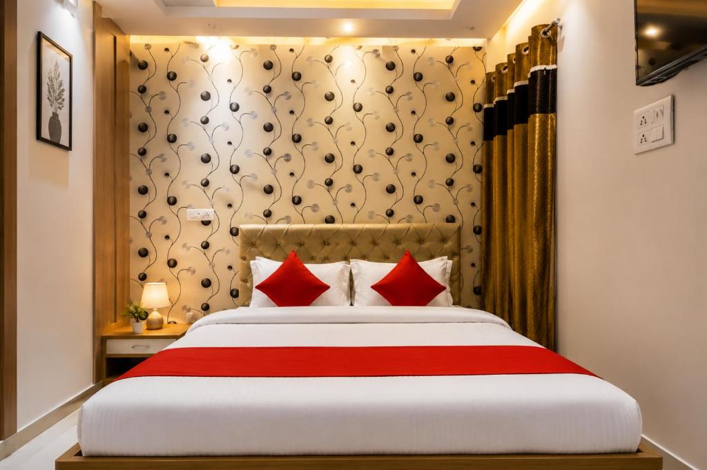 a bedroom with a large bed with red pillows at Hotel Amrapali Udaipur in Udaipur