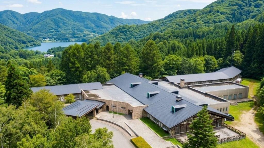 an aerial view of a building with mountains in the background at WHITE HOTEL GRAND HAKUBA in Omachi
