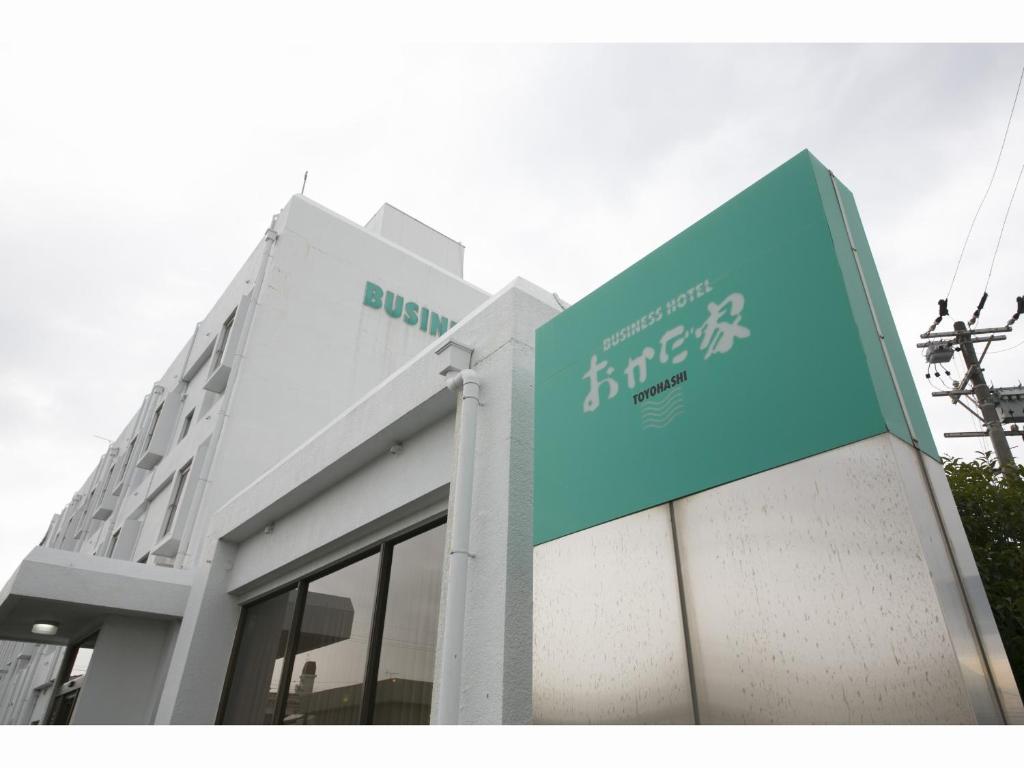 un edificio con una señal azul en el costado. en Business Hotel Okada Toyohashi en Toyohashi