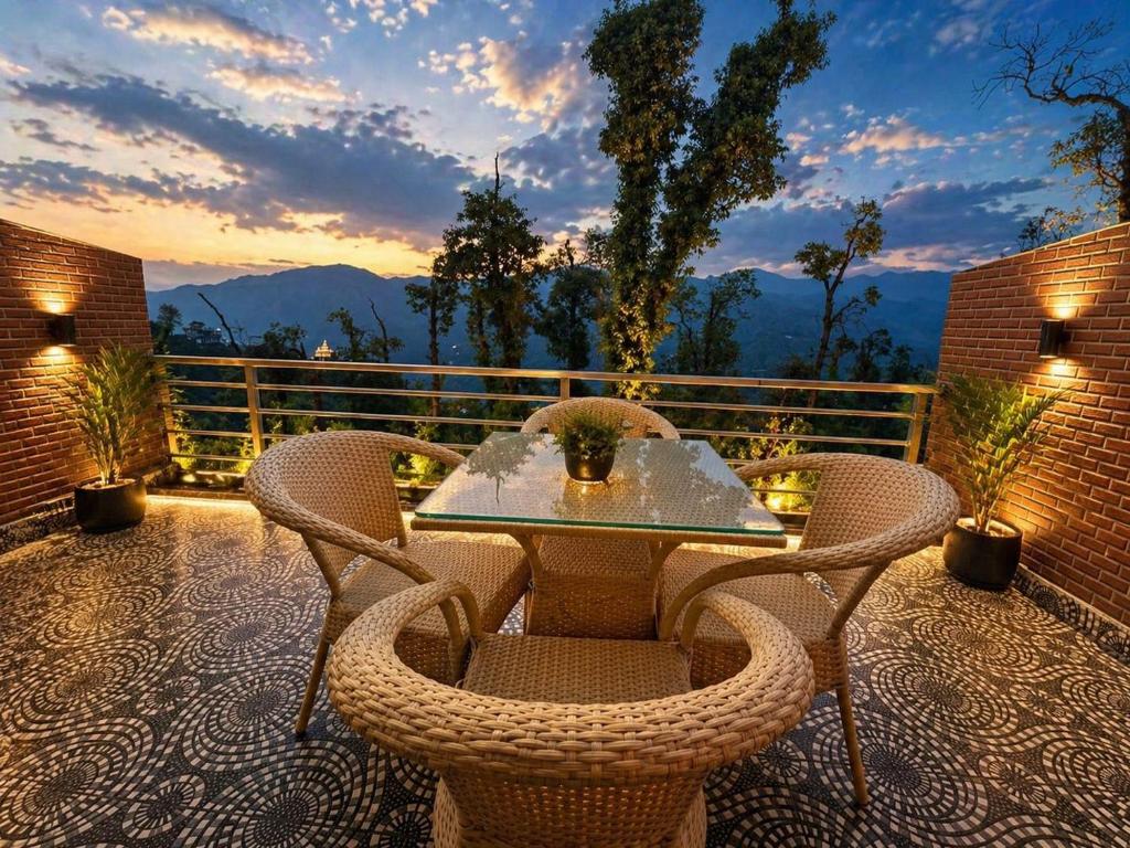 a patio with a table and chairs on a balcony at Grand Vista Retriet- A luxury Mountain View Property In Mussoorie By Lilly in Mussoorie