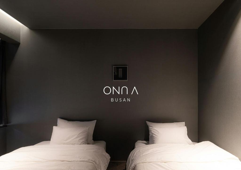 two beds sitting next to each other in a room at ONUA Gwangalli in Busan
