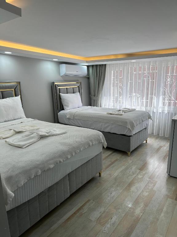 a bedroom with two beds and a window at lord ımmortelle apartment in Istanbul