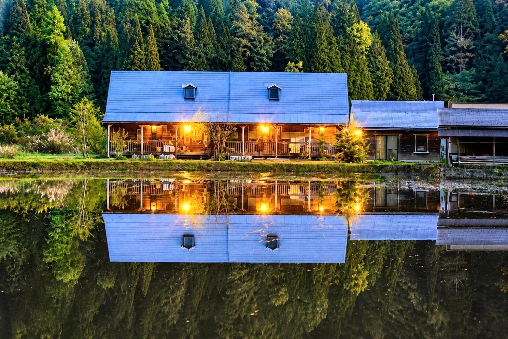 a house on the water with its lights on at 実と來-mitoki in Takayama