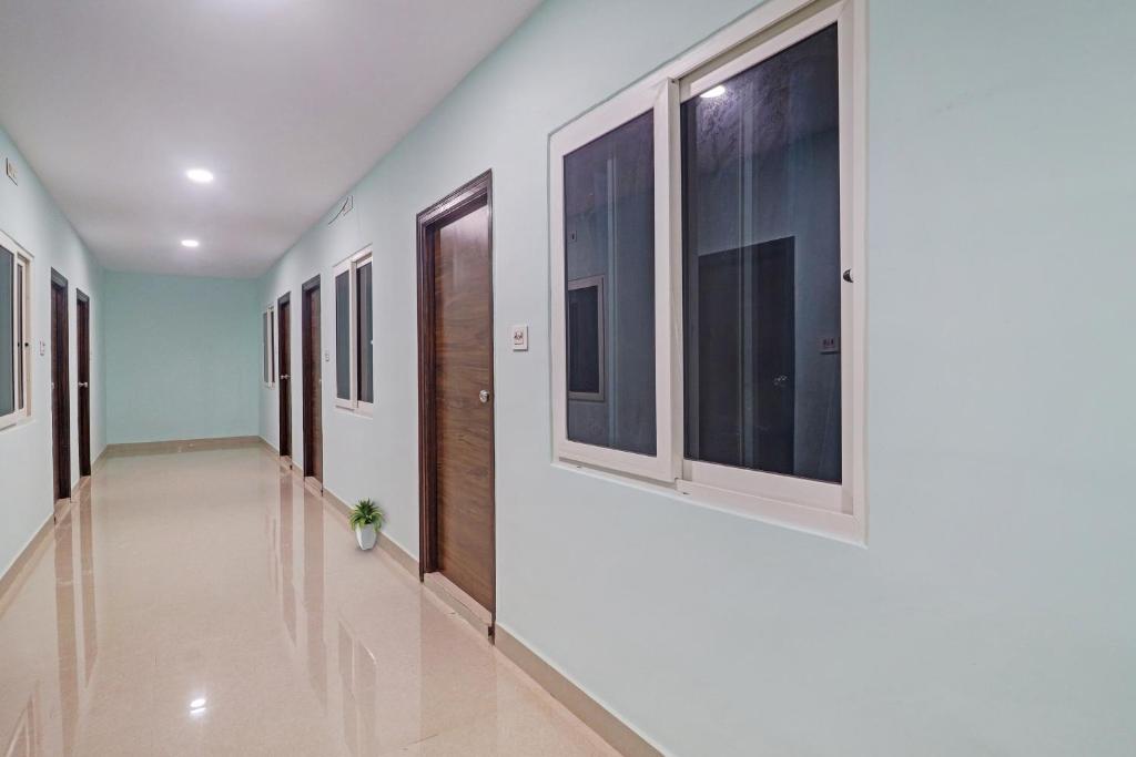 a hallway with windows in a hospital with a floor at Hotel O Langar Houz Near Golconda Fort in Hyderabad