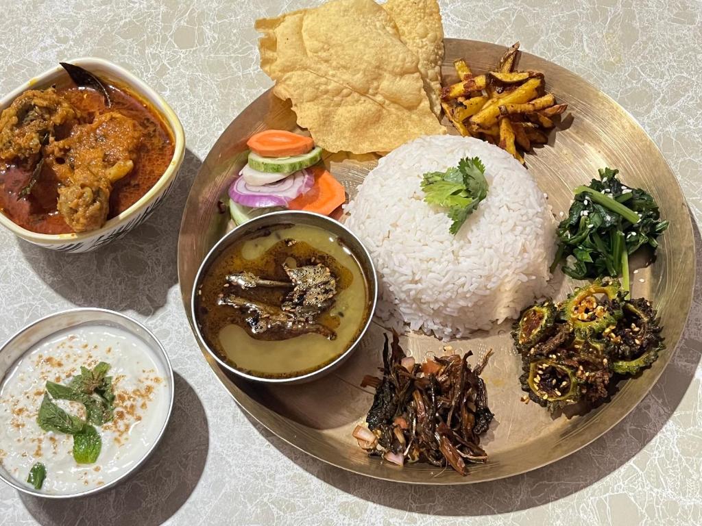 a plate of food with rice and other foods at Riyang Homestay in Mirik