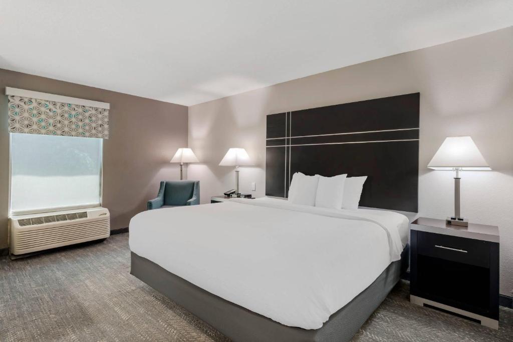 a bedroom with a large white bed and a large window at Quality Inn & Suites Union City - Atlanta South in Union City