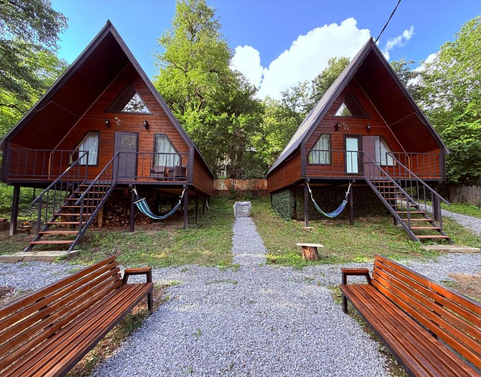 two buildings with benches in front of them at Glola A-Frame Cottages in Glola