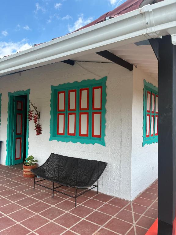 a house with red windows and a bench outside at Masinga FarmHouse in Filandia