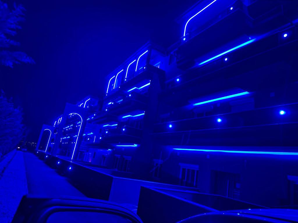 a building with blue lights on the side of it at Milaluxe in Paralia Katerinis