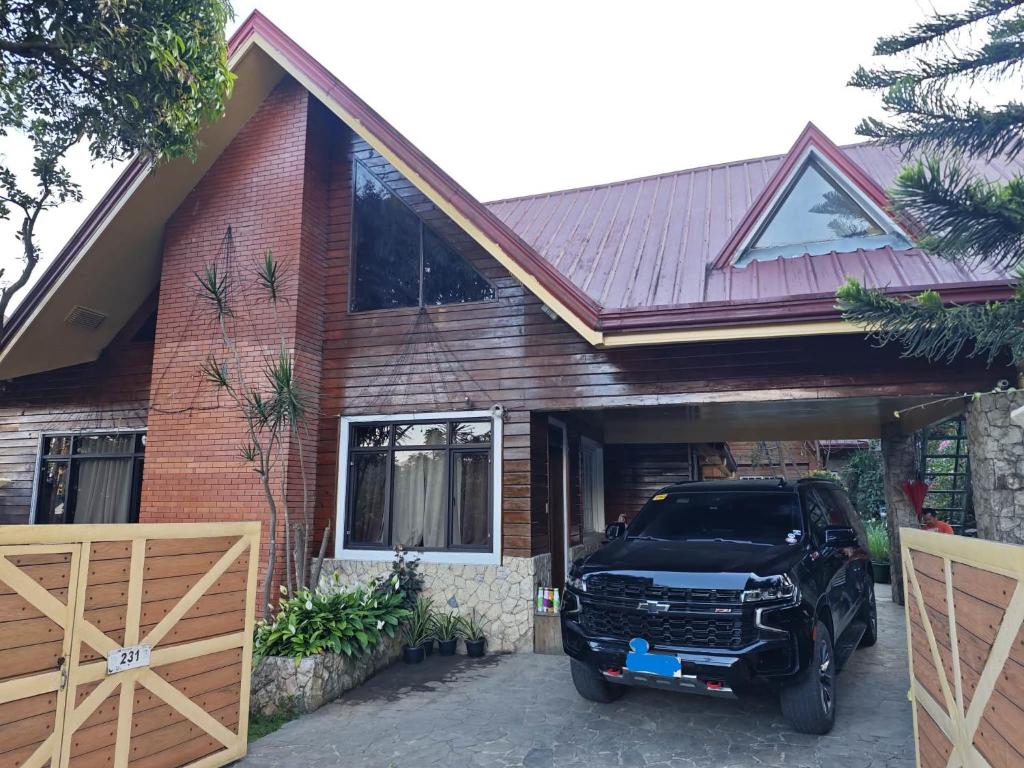 a car parked in front of a house at Sangria Pinesview Chalet in Baguio