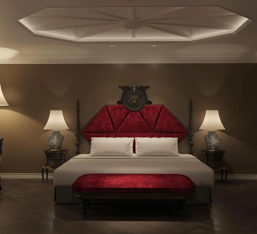 a bedroom with a large bed with a red headboard at Hôtel Le Joyau Bleu Hanoï in Hanoi