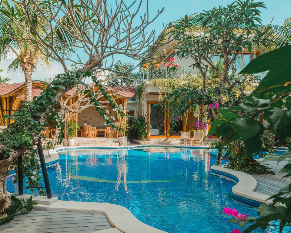 a pool at a resort with trees and a building at MJ Villa Sanur in Sanur