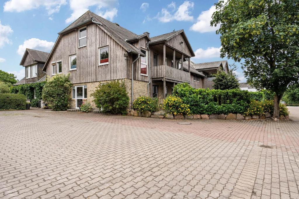 a large house with a brick driveway at Cattle Barn - leben auf dem Hof in Tröndel