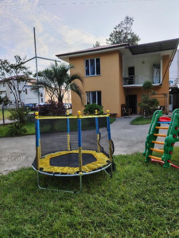 a playground in the grass in front of a house at Giomari in Shekhvetili