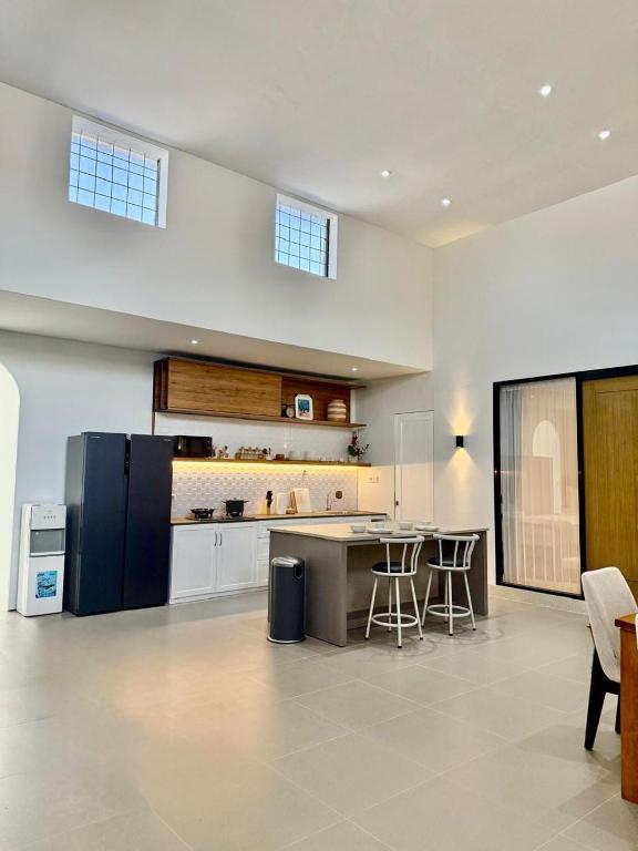 a large kitchen with a refrigerator and a counter at Kuraya Urban Space in Surabaya