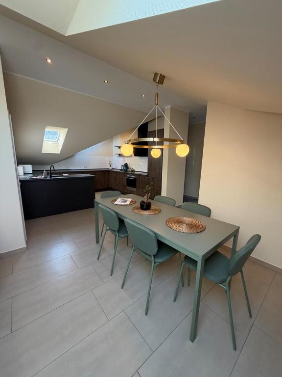 a dining room with a green table and chairs at N90 Living in Karlsruhe
