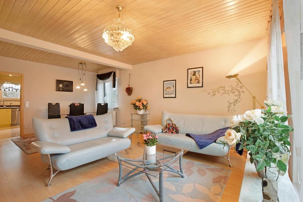 a living room with white furniture and a chandelier at Sandra in Berghülen