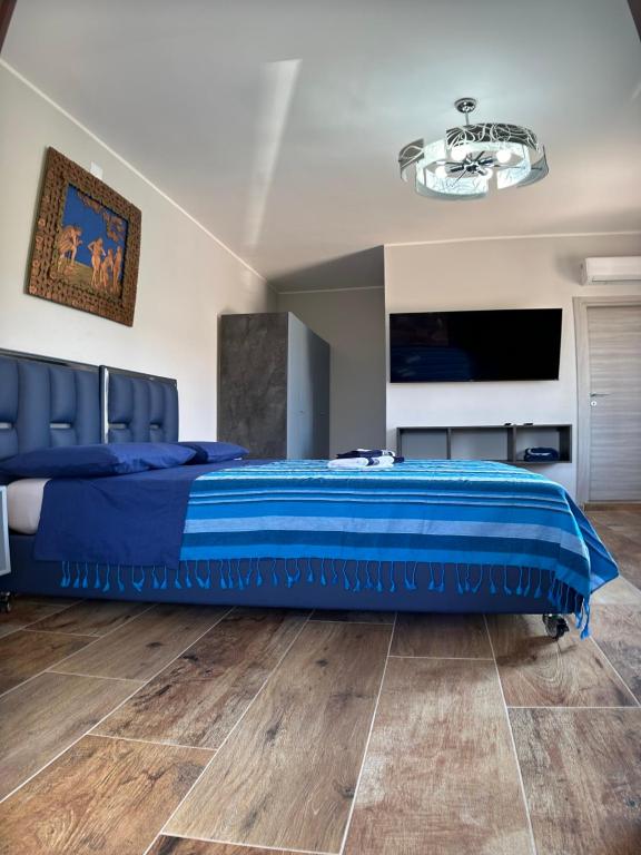 a bedroom with a bed with a blue comforter at Antiche Torri Guest House in Castel Volturno