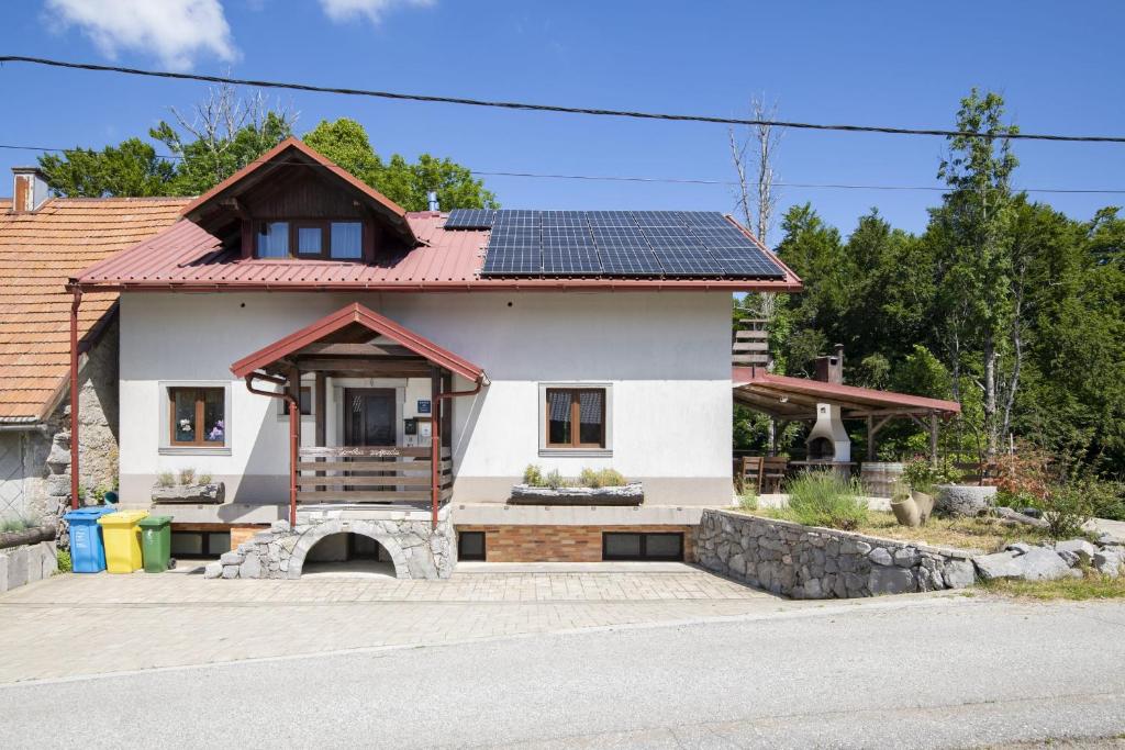 a house with solar panels on the roof at Mountain Escape house with indoor pool in Fužine