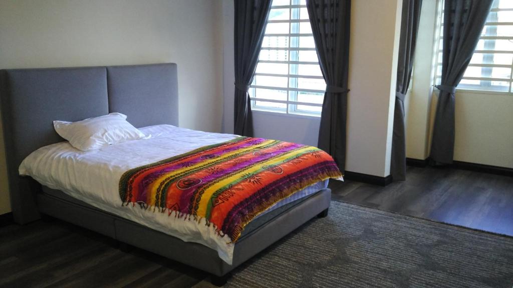 a bedroom with a bed with a colorful blanket on it at Leong Homestay Kuantan in Kuantan