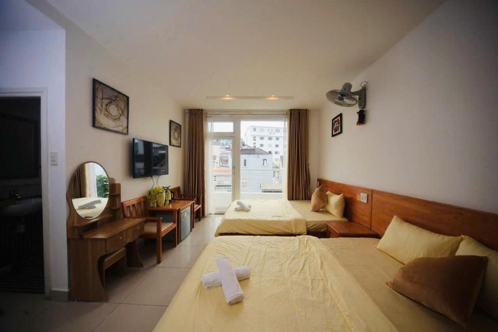 a room with two beds with a cross on them at New Sun Hotel in Da Lat