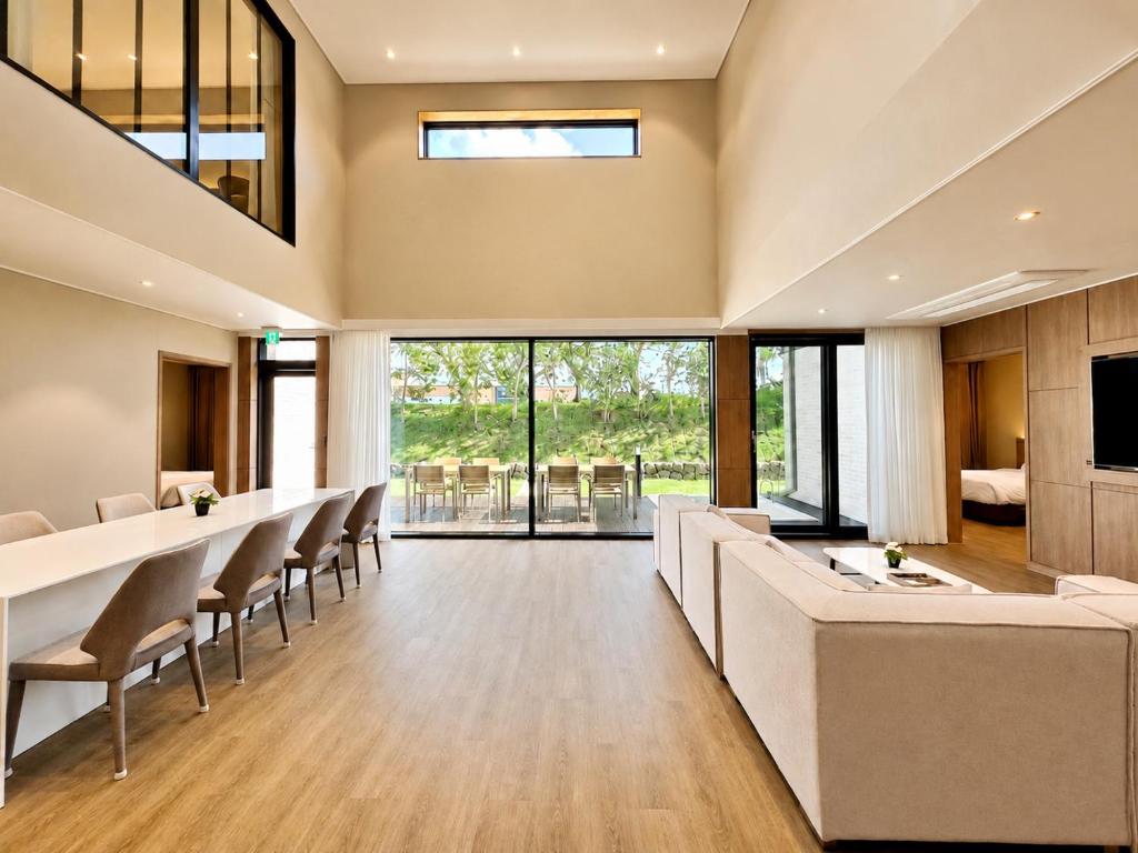 a large living room with a long table and chairs at The Brighton Hamdeok in Jeju