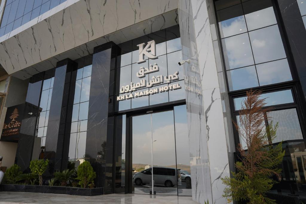 a building with a sign on the front of it at KH La Maison in Abha