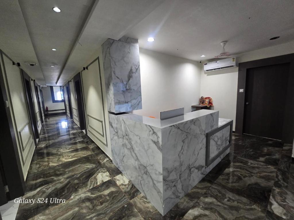 a hallway with a marble counter in a building at Hotel Saffron in Vadodara