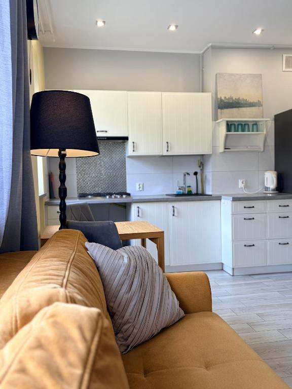 a living room with a couch and a kitchen at Apartament COMFORT Centrum in Krotoszyn