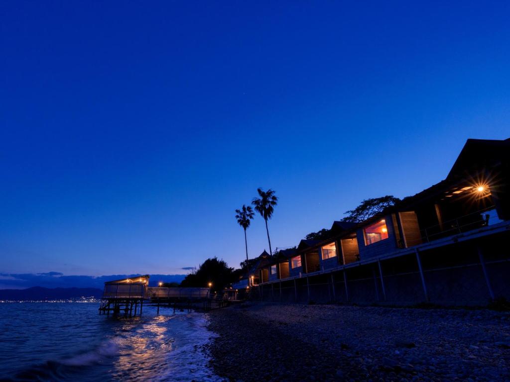 a beach at night with palm trees and the water at Costa Del Sol HIJI in Hiji