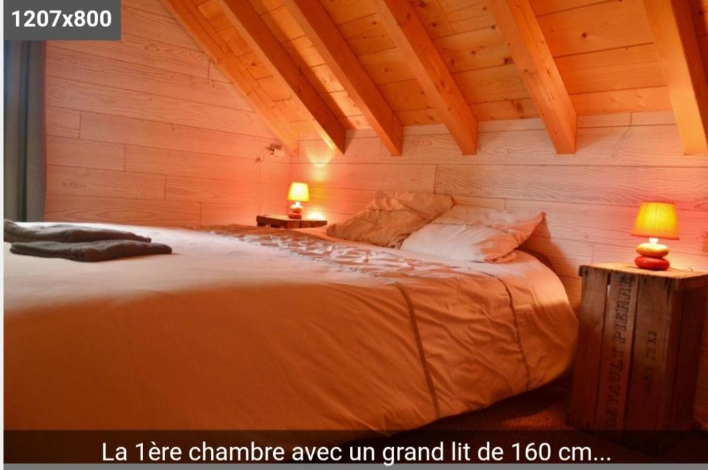 a bedroom with a large bed with two lamps at pas dispo moins de 5 nuits Ecogite du lac in La Thuile