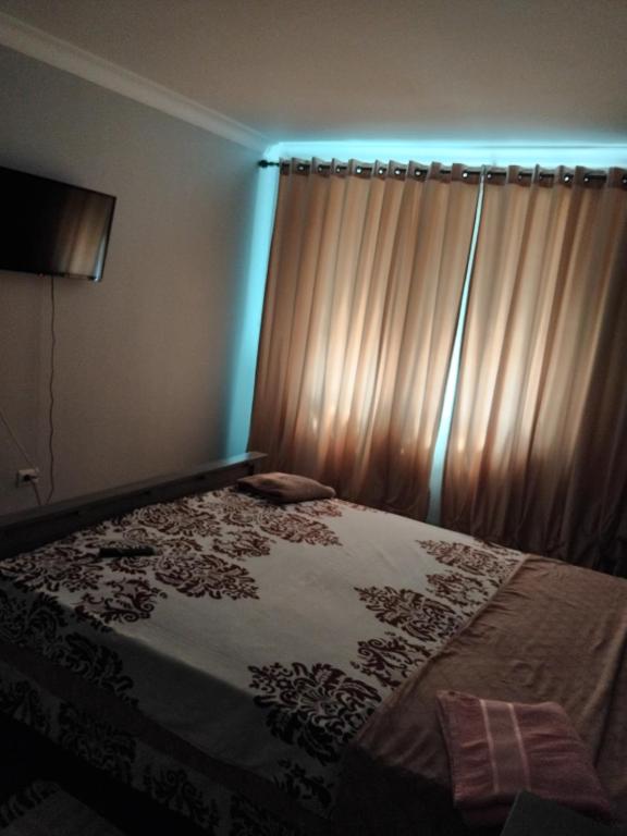 a bedroom with a bed with a window with curtains at Residence Manu Tg Neamț in Târgu Neamț
