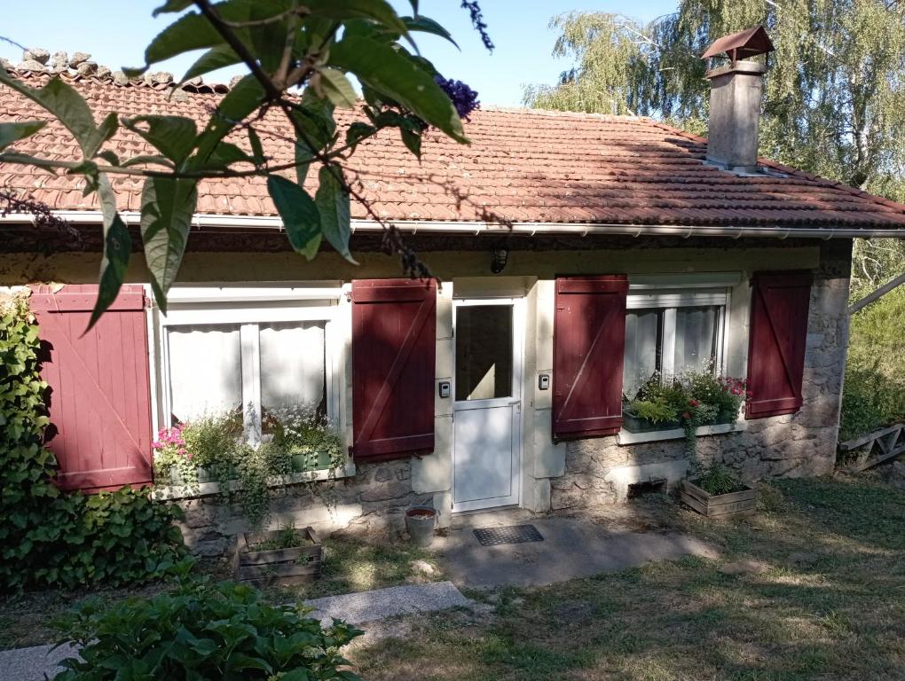 a small house with red doors and windows at B&B Les Paddocks in Vollore-Montagne