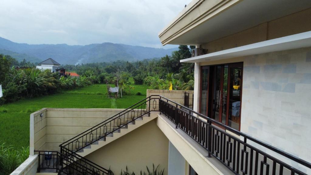 a balcony of a house with a view of a yard at Qiana House in Manggis