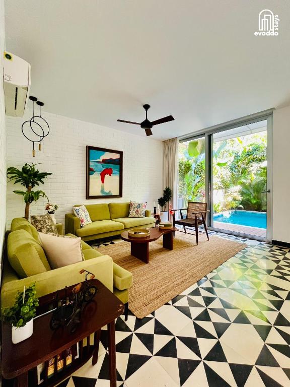 a living room with a yellow couch and a table at SolVanya by evaddo stays 2BHK Luxury Villa with Private Pool in Siolim in Siolim