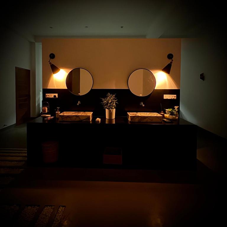 a bathroom with two sinks and two mirrors on the wall at Chez Colette in Matara