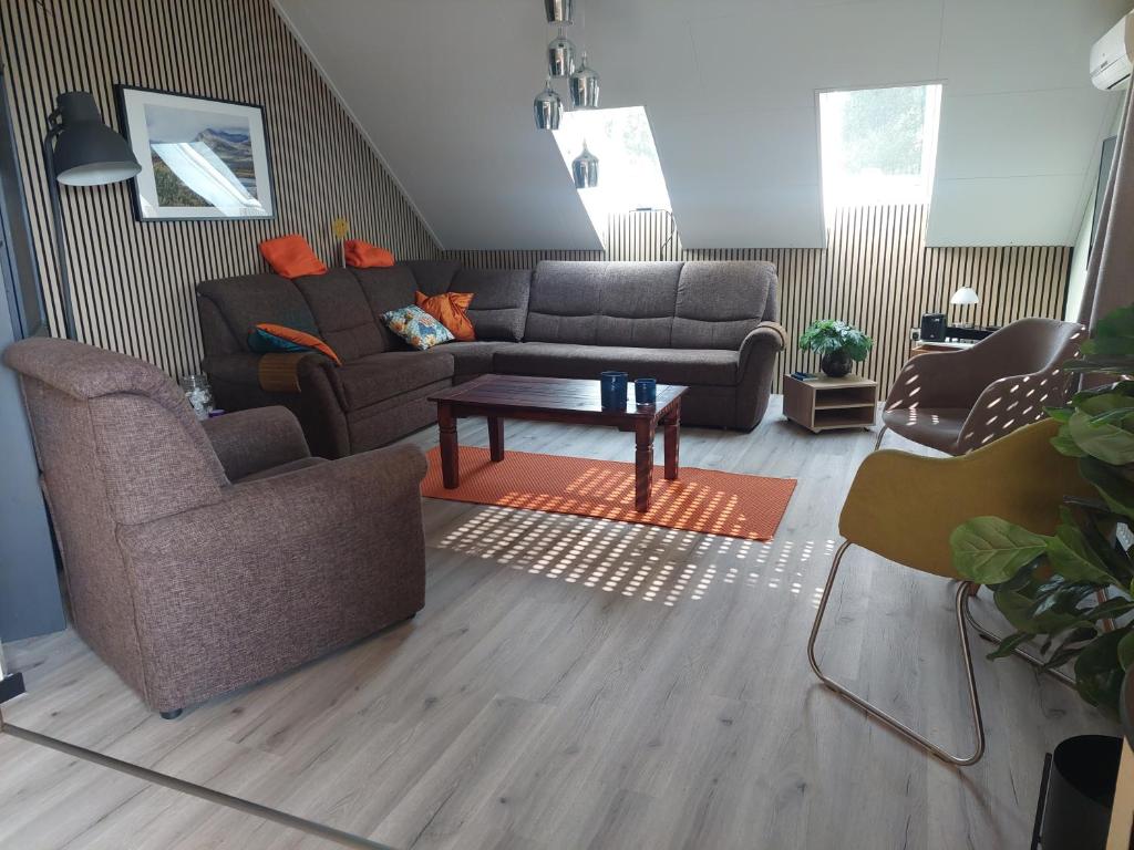 a living room with a couch and two chairs at Narnia in Heede