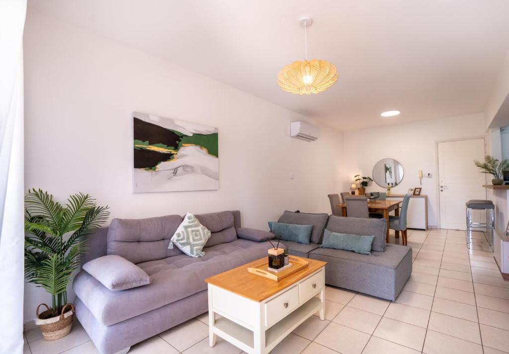 a living room with a couch and a table at Cozy Apartment in Paphos Beautiful Complex in Paphos