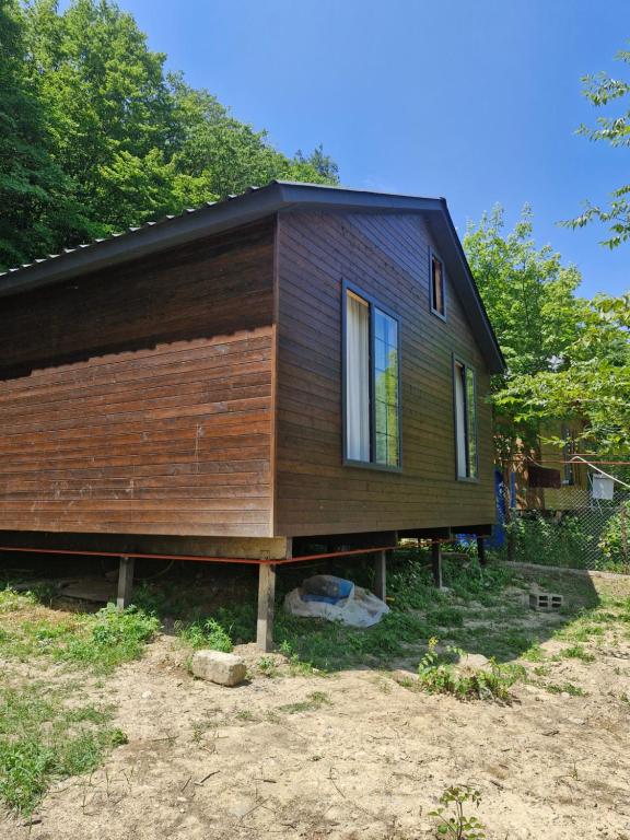 a house that is sitting in the grass at Cottage in Tskhvarichamia forest 2 in Tsʼkhvarichamia