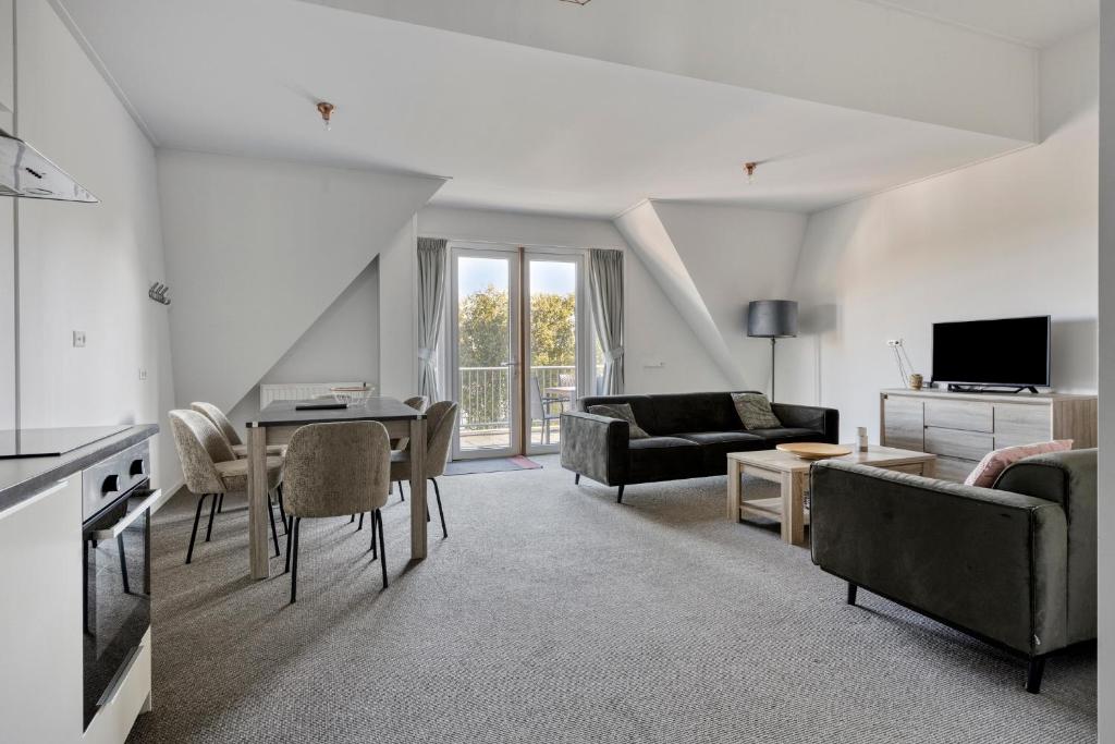 a living room with a couch and a table at Penthouse DeLuxe in Oostkapelle