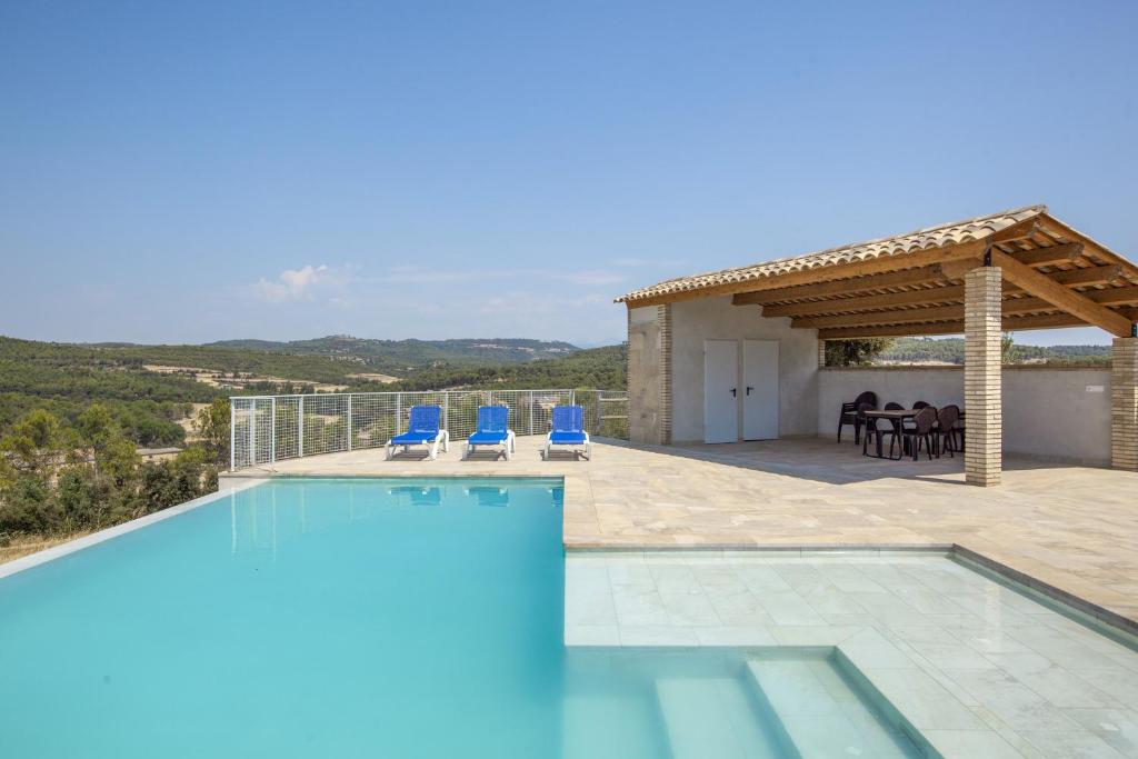 a villa with a swimming pool and a patio at Cal Potret in Argençola