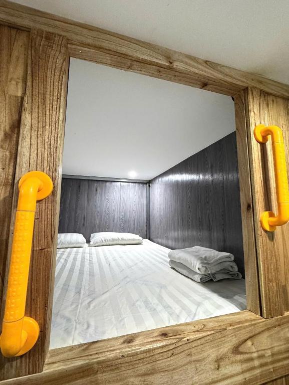a room with a bed in a wooden wall at VNJ Capsule 216 in Hoi An