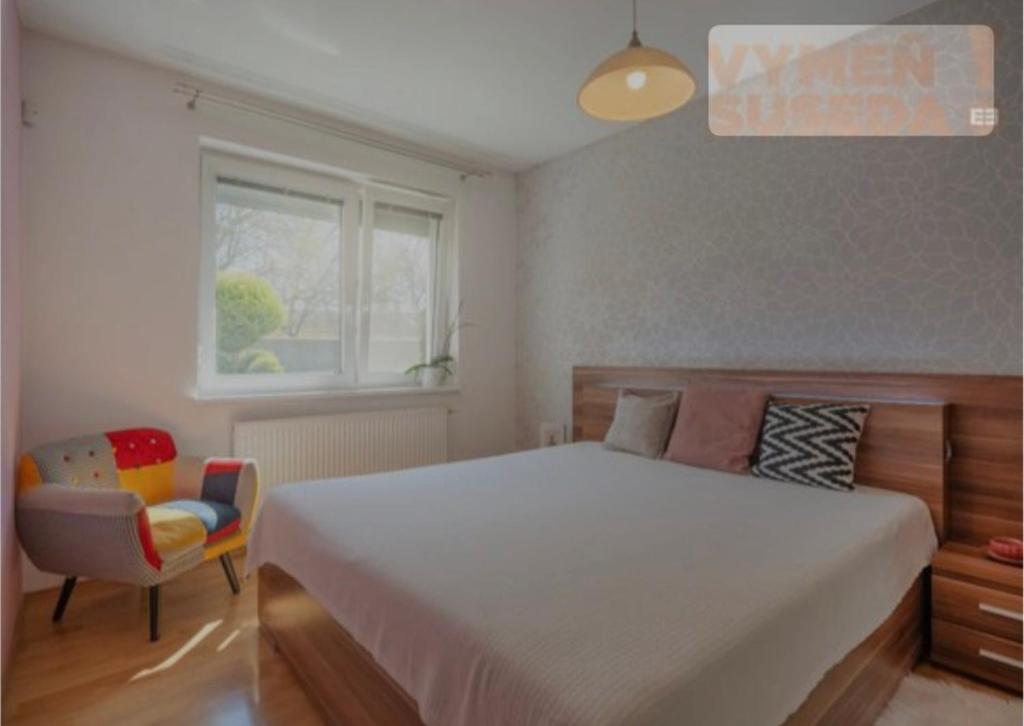 a bedroom with a bed and a chair and a window at Amir Guesthouse in Chon-Dzhargylchak
