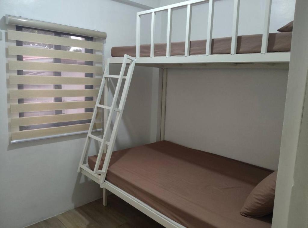 a bunk bed with a ladder in a room at DVM Transient Inn by RedDoorz in Santo Tomas