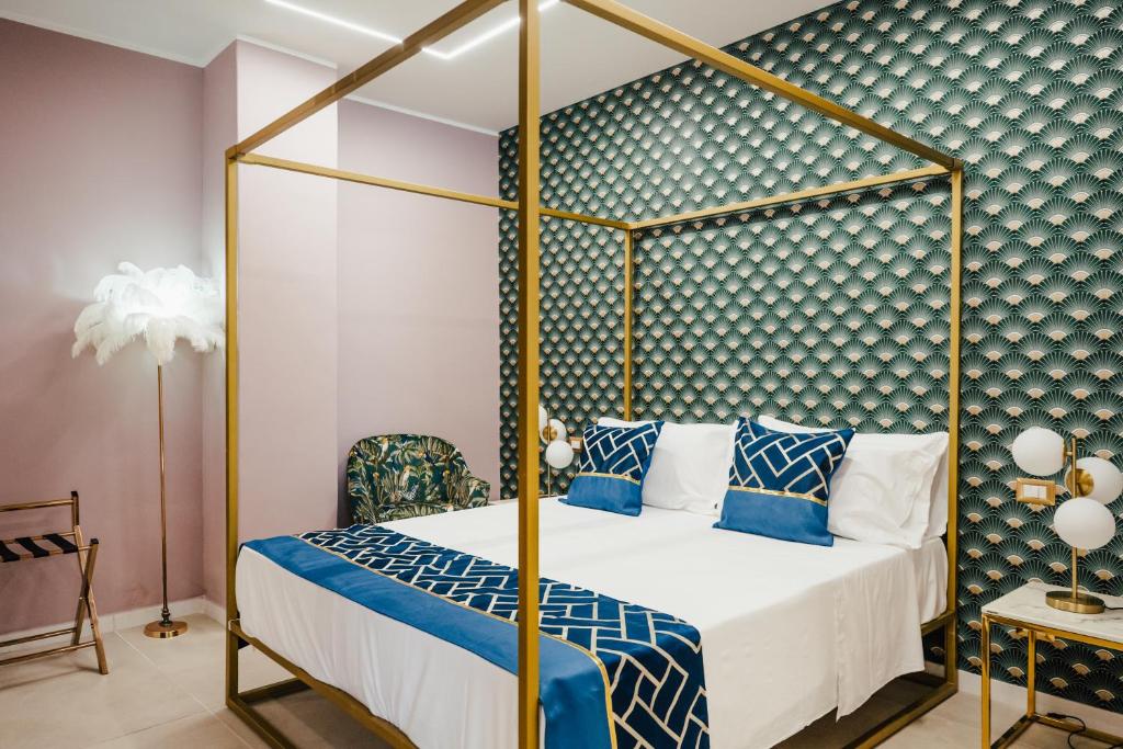 a bedroom with a canopy bed with blue and white pillows at Le Pepite Collection in Giardini Naxos
