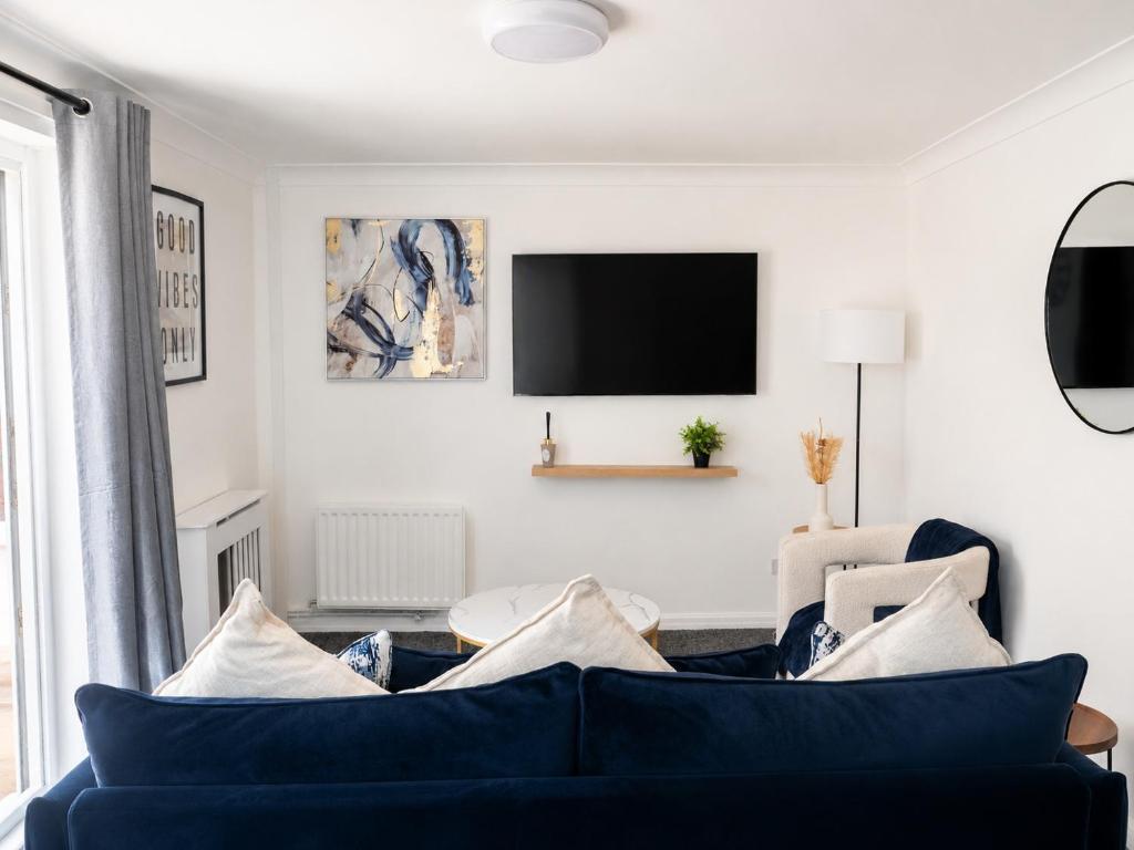 a living room with a blue couch and a tv at iblets in Gravesend